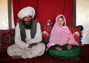 Portrait of soon to be wed Faiz Mohammed, 40, and Ghulam Haider, 11, at her home in a rural village of Damarda in Ghor province. Ghulam said she is sad to be getting engaged as she wanted to be a teacher. Her favorite was Dari, the local language, before she was made to drop out of school. Married girls are seldom found in school, limiting their economic and social opportunities. Parents sometimes remove their daughters from school to protect them from the possibility of sexual activity outside of wedlock. It is hard to say exactly how many young marriages take place, but according to the Afghan women's ministry and women's NGOs, approximately 57 percent of Afghan girls get married before the legal age of 16. In addition, once the girl's father has agreed to the engagement, she is pulled out of school immediately. Early pregnancies also result in an increase in complications during child birth.